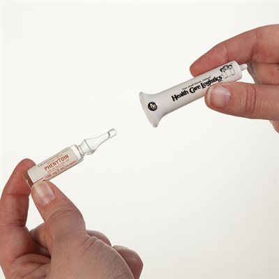 A small glass vial labeled "PHENYTOIN" is held, alongside a white plastic applicator labeled "Health Care Logistics." The context is a clean, bright background.