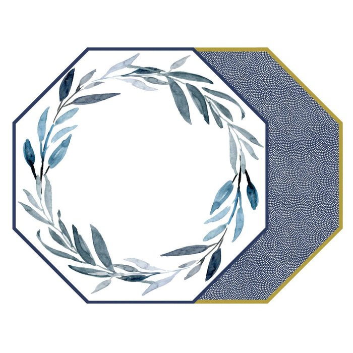 Octagonal plate with a blue leafy wreath on white and navy border sits atop another plate with blue dots and gold trim, all accented by the HOLLY STUART DESIGNS - WATERCOLOR LEAVES PLACEMAT IN BLUE from HOLLY STUART DESIGNS.