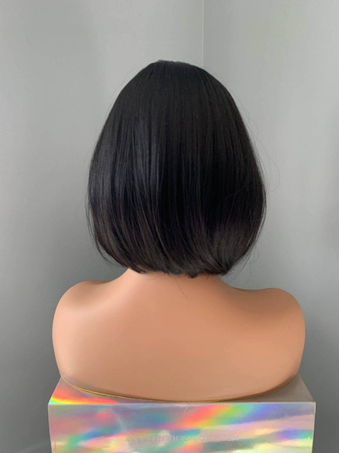 Mannequin head with black bob haircut against a gray background