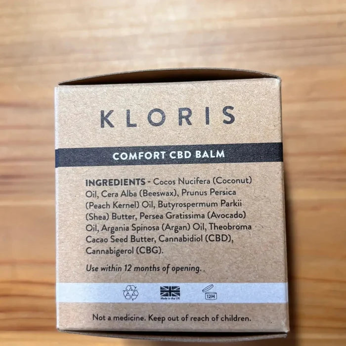 Kloris Comfort CBD Balm packaging on a wooden surface