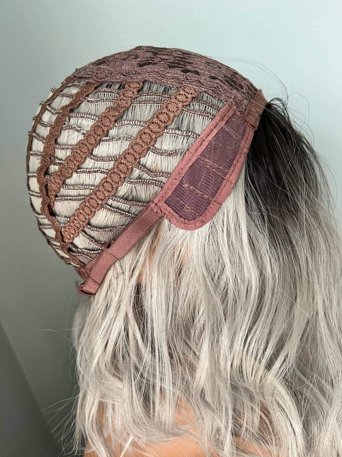 Person wearing a brown lace headband with a plain background