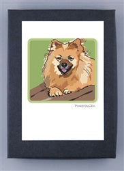 PAPER RUSSELLS - POMERANIAN BOXED CARDS feature a fluffy, light brown dog with pointed ears and a happy face on green, framed by a dark border. Printed on recycled paper and proudly made in the USA by PAPER RUSSELLS.