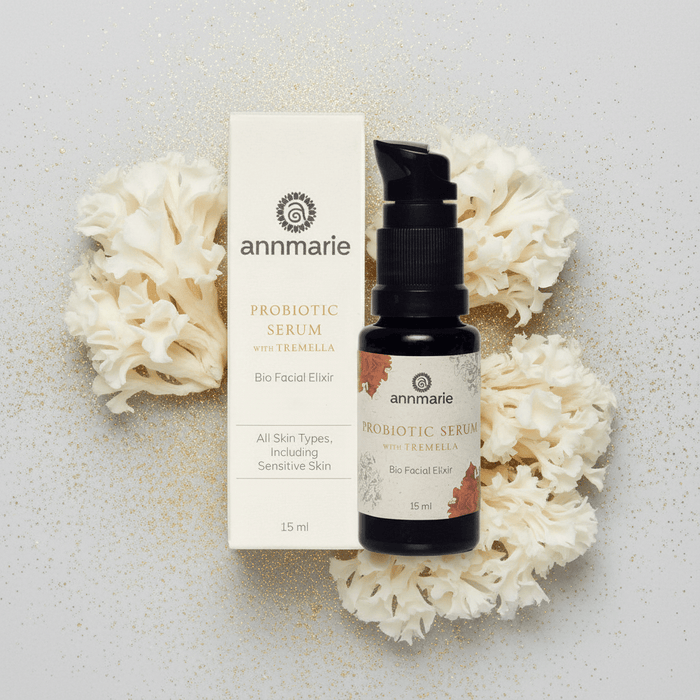 Annmarie Probiotic Serum with packaging on a textured surface with white flowers.