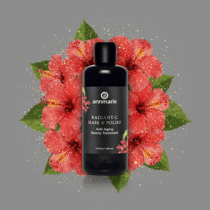 Black bottle of 'Radiant-C Mask & Polish' surrounded by pink flowers on a gray background