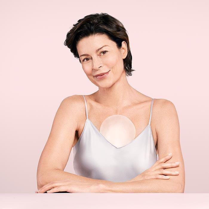 A pink SIO CHESTLIFT box from SIO BEAUTY sits beside a clear sheet holding two reusable, medical-grade silicone patches shaped to treat chest wrinkles.