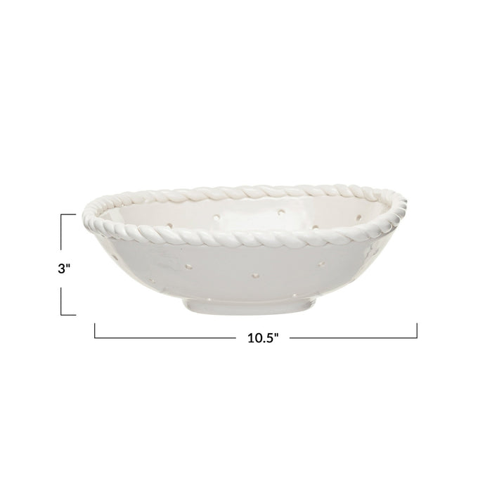 The CREATIVE COOP STONEWARE COLANDER WITH HAND TWISTED EDGE, shown holding three grapefruits on a light textured surface, adds farmhouse charm to any kitchen.