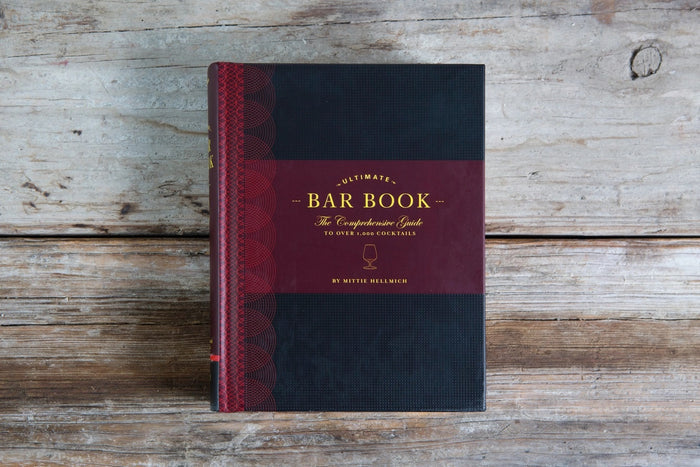 Cover of THE ULTIMATE BAR BOOK: THE COMPREHENSIVE GUIDE TO OVER 1,000 COCKTAILS BY MITTIE HELLMICH from CHRONICLE BOOKS, featuring a brown and olive green design with a wine glass icon—ideal for fans of classic cocktails.