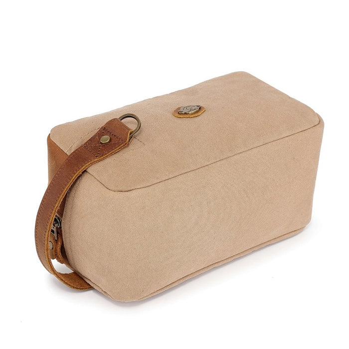 The TSD BRAND - VALLEY OAK TOILETRY BAG IN KHAKI is a handcrafted toiletry bag with a handle, shown open from above to reveal its empty beige fabric-lined interior—perfect for organized travel.