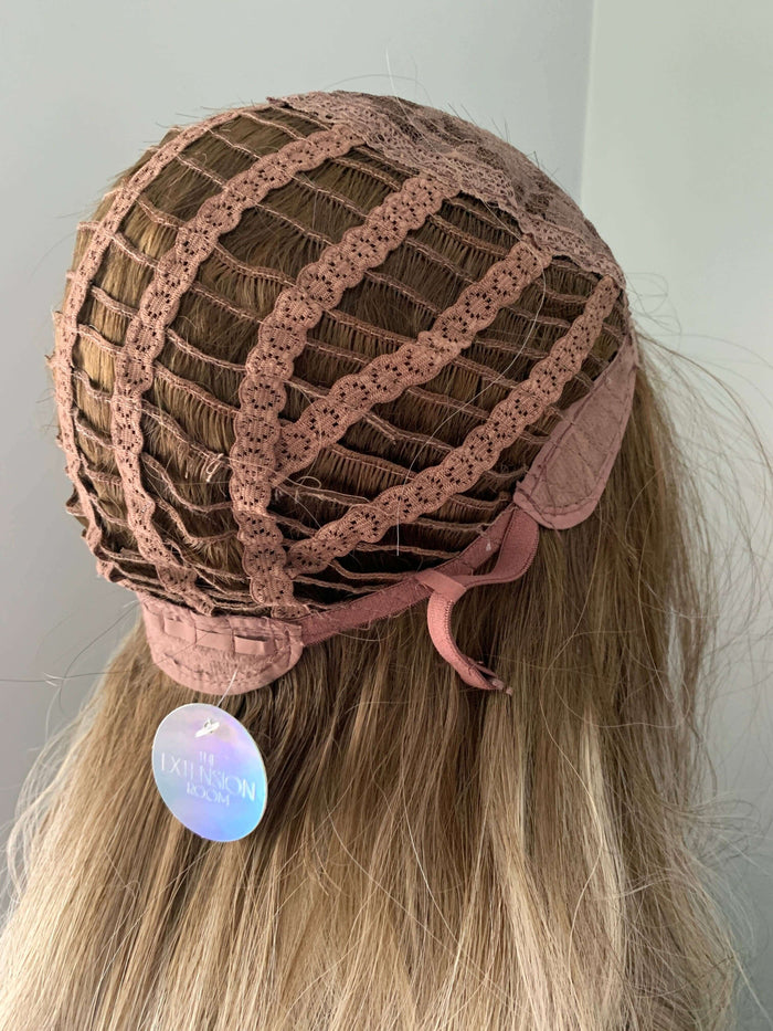 Back view of a wig cap showing lace details and adjustable straps for secure fit.