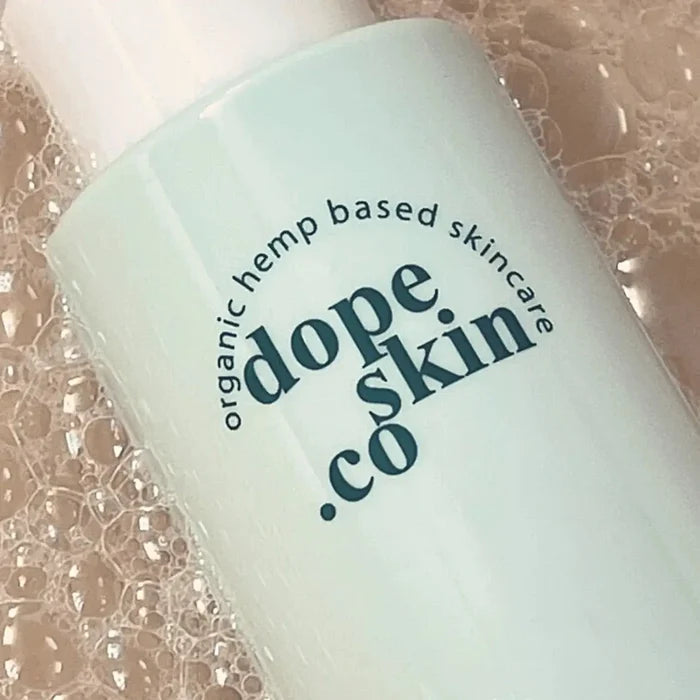 Skincare bottle labeled 'dope skin co' on a textured background