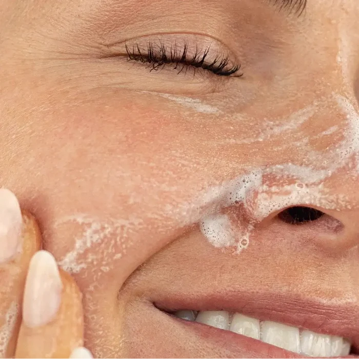Close-up of a person applying cream to their face