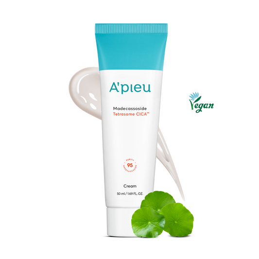 A'pieu Madecassoside Tetrasome Cica Cream in a white tube with blue accents, alongside a spoonful of the cream and a few leaves of Centella Asiatica.