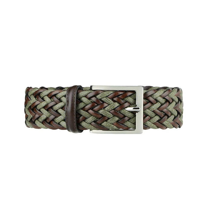 A person wears a light green shirt tucked into cream pants, hands in pockets, accessorized with the ATHISON braided leather and linen belt in dark brown and olive. Lush greenery fills the background.