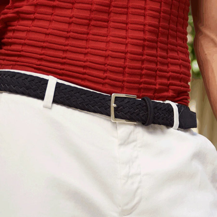 The ATHISON - BRAIDED SUEDE BELT IN INDIGO by ATHISON features braided Italian suede and a silver rectangular buckle, shown coiled in a loop on a white background.