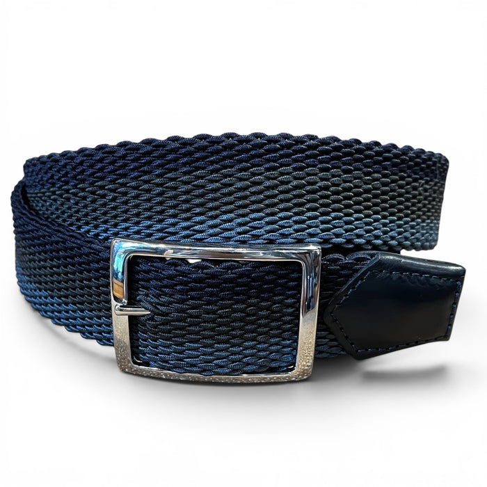 A close-up of the ATHISON reversible stretch belt featuring indigo, manatee, and light blue stripes reversing to solid indigo, with a textured finish and a silver rectangular buckle on a white background.