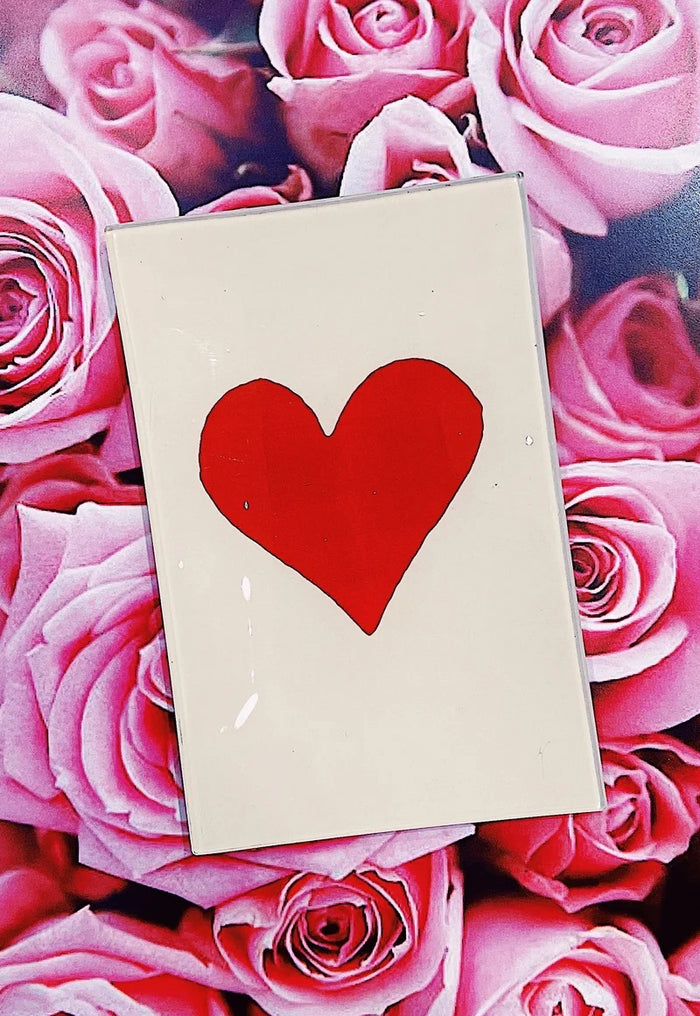 A playing card featuring a bold red heart in the center, inspired by the BEN’S GARDEN - RED LONG HEART DECOUPAGE GLASS TRAY, set against a beige background with a glossy finish that echoes the brand’s signature handcrafted decoupage style from BENS GARDEN. This design perfectly reflects the distinctive charm of the Red Long Heart motif.