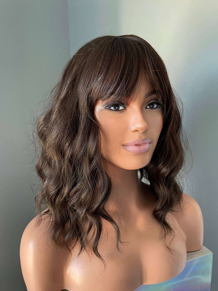 Bianca Short Dark Brown Wig with Bangs displayed on a mannequin, featuring soft waves and full bangs for a sophisticated look.