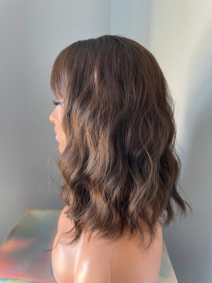 Side view of a Bianca Short Dark Brown Wig with Bangs featuring soft body waves and a flattering bob length.