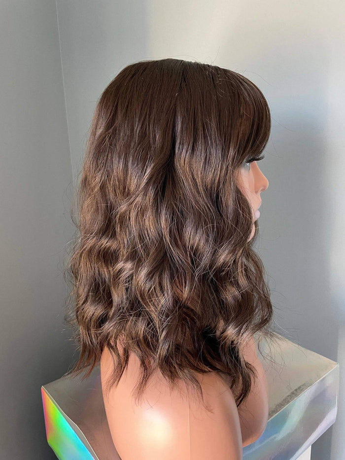 Bianca Short Dark Brown Wig with Bangs displayed on a mannequin, featuring soft body waves and a flattering bob length.