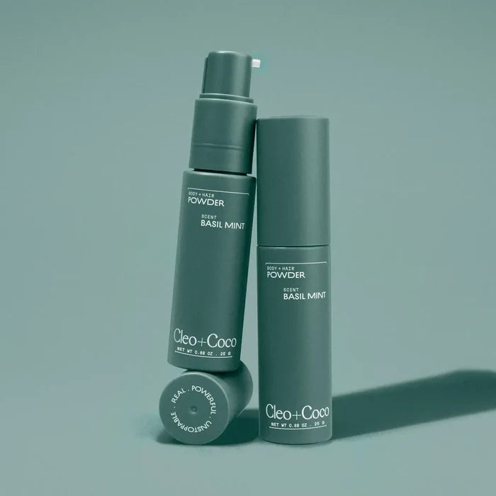 Two green bottles labeled 'Cleo+Coco' on a matching green background