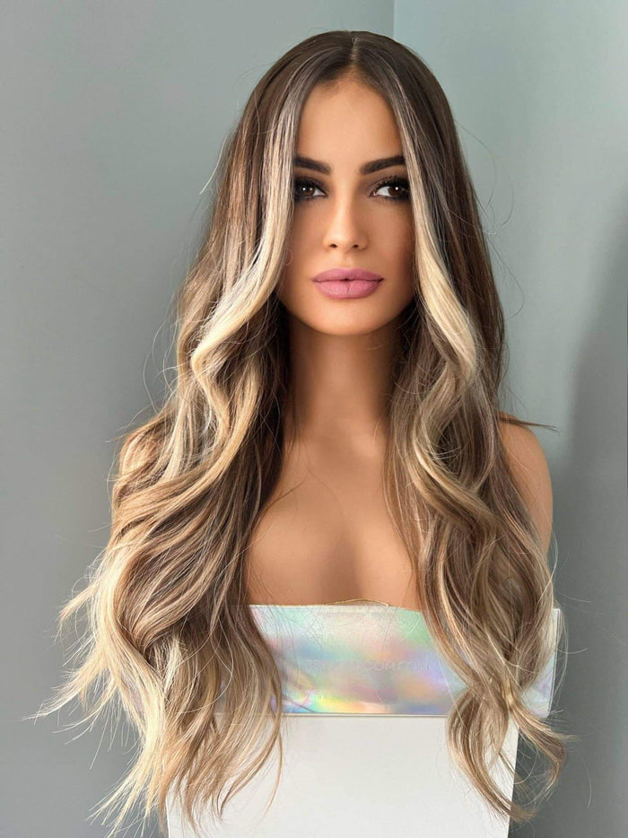 Brianna Long Brown Wig With Highlights styled on a model, featuring soft brown waves and blonde highlights.