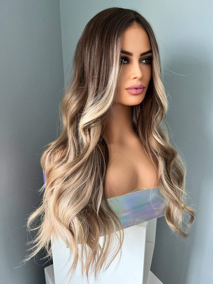 Brianna Long Brown Wig With Highlights featuring soft brown waves and blonde highlights for a natural look.