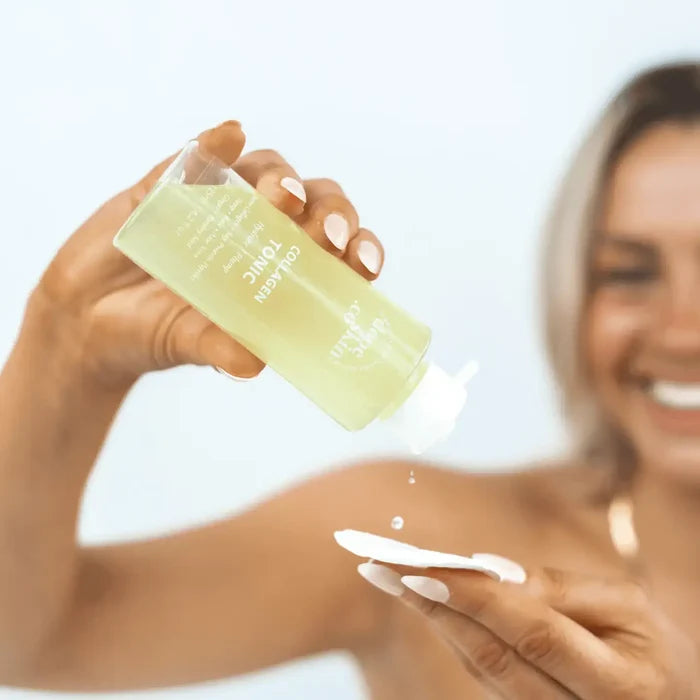 Woman applying a green skincare product to her arm with a blurred background