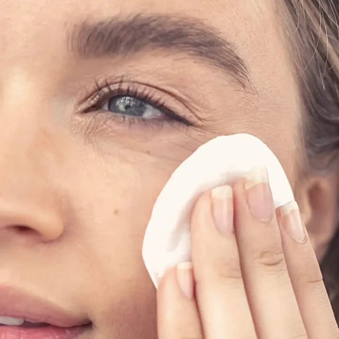Person cleaning their eye with a cotton pad