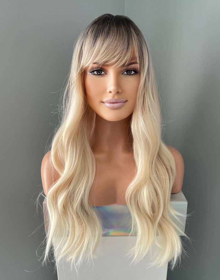 Mannequin head with long blonde wig on a gray background