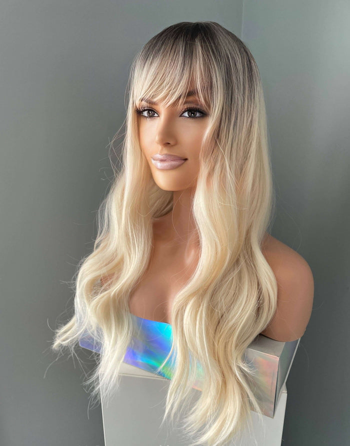 Mannequin head with long blonde wig on a gray background
