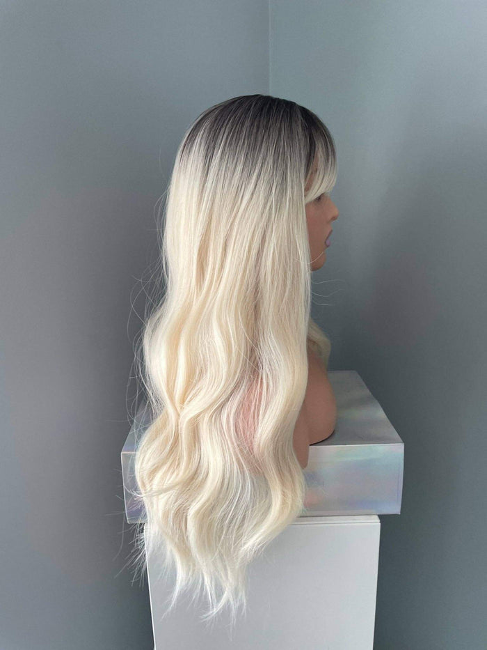 Mannequin head with long, wavy blonde hair on a gray background
