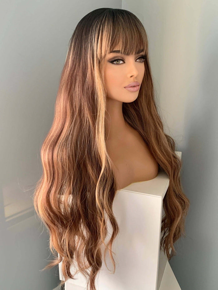 Highlighted Wig featuring long, highlighted brown body waves and bangs for a glamorous look.