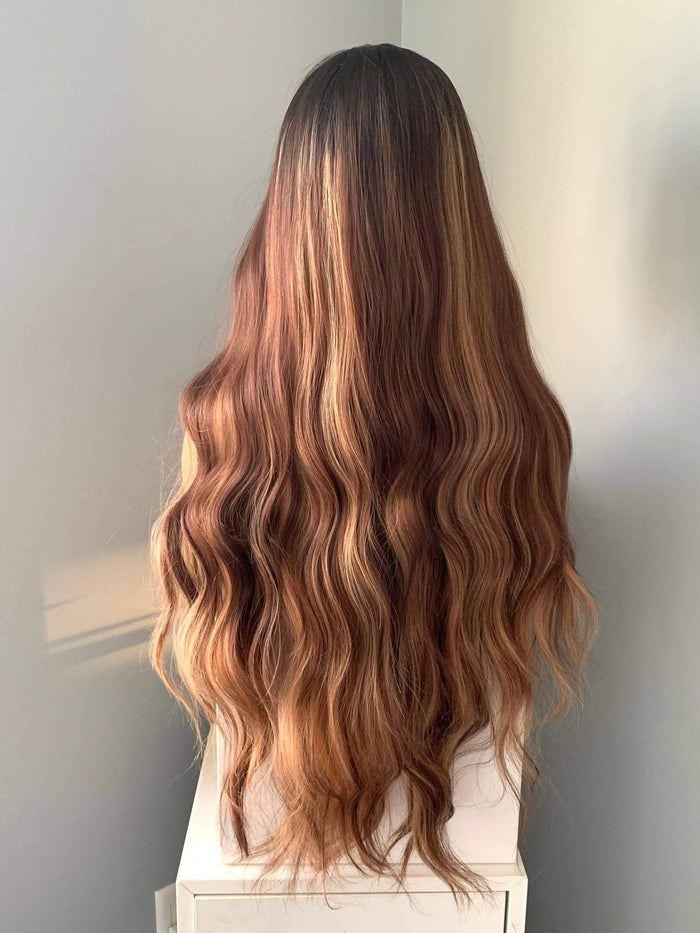 Long, wavy hair with a gradient color on a neutral background