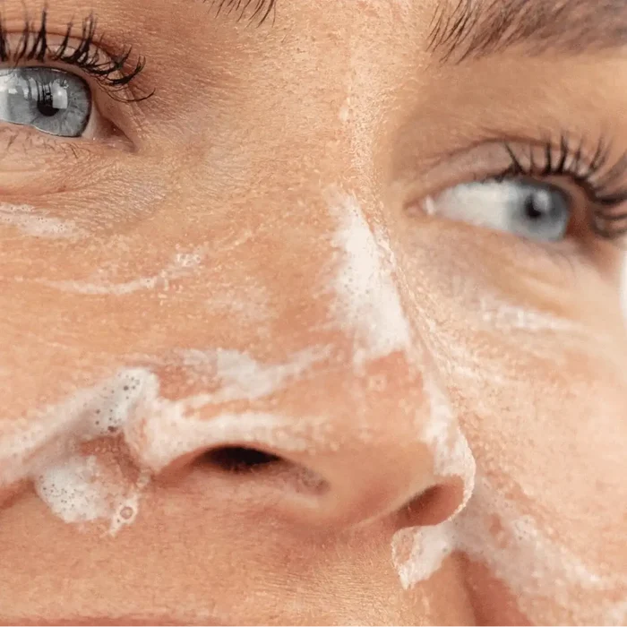 Close-up of a person's face with soap bubbles on the skin