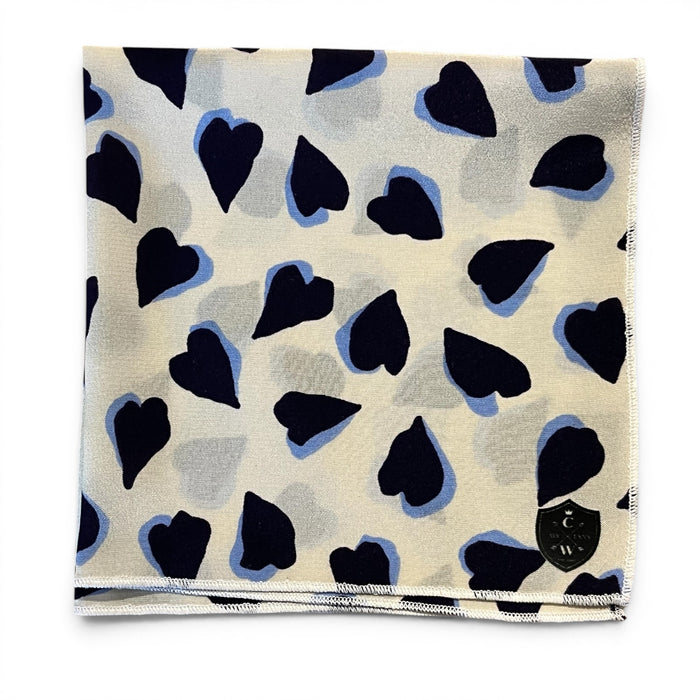 The CLIFTON WILSON Navy and White Hearts Silk Pocket Square features irregular navy and black heart motifs with light blue outlines—a unique, stylish accessory ideal for weddings or special occasions.
