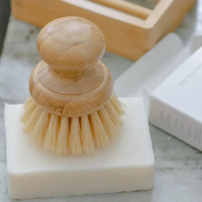 Wooden dish brush on a block of soap with a blurred background