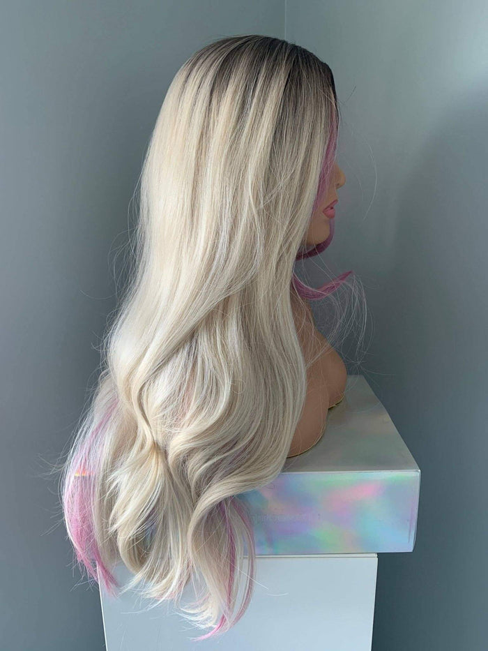 Mannequin head with long blonde wig on a white stand against a gray background