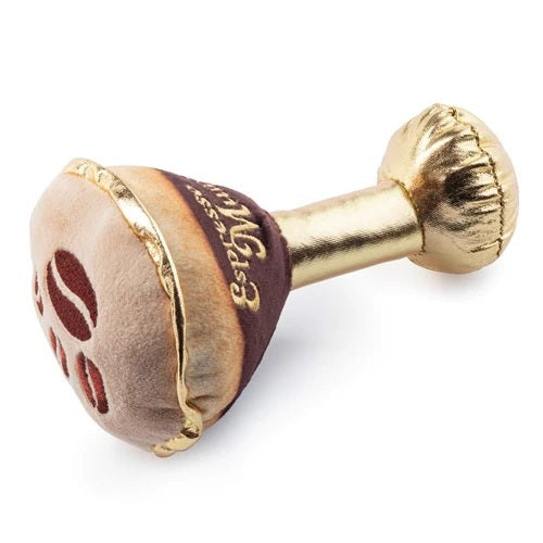 The ESPRESSO MUTTINI DOG TOY by HAUTE DIGGITY DOG is a plush dog toy designed to resemble a martini glass, featuring a gold stem and base, brown “liquid,” and a tan top with a charming paw print detail. "Espresso Mutini" is embroidered on the side, and an engaging squeaker inside ensures hours of fun for your pup.
