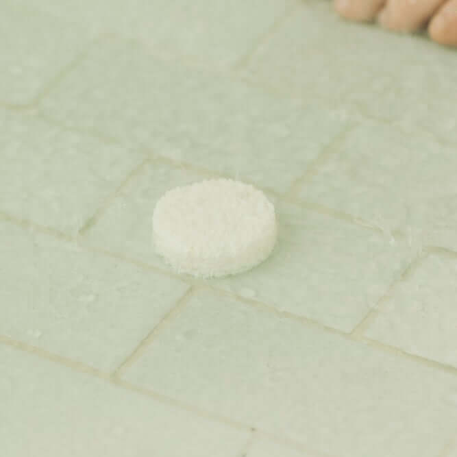 White stone on a light green tiled floor