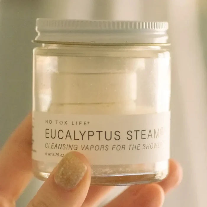 Jar of Eucalyptus Steam Cleansing Vapors for the Shower held by a hand.