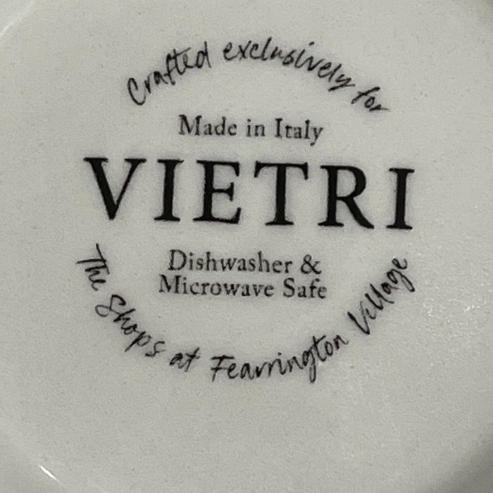 The FEARRINGTON SIGNATURE COLLECTION Beltie Oval Platter by VIETRI features black cow and calf silhouettes on green grass with blue clouds on a cream base, making it a charming gift inspired by Fearrington Village.