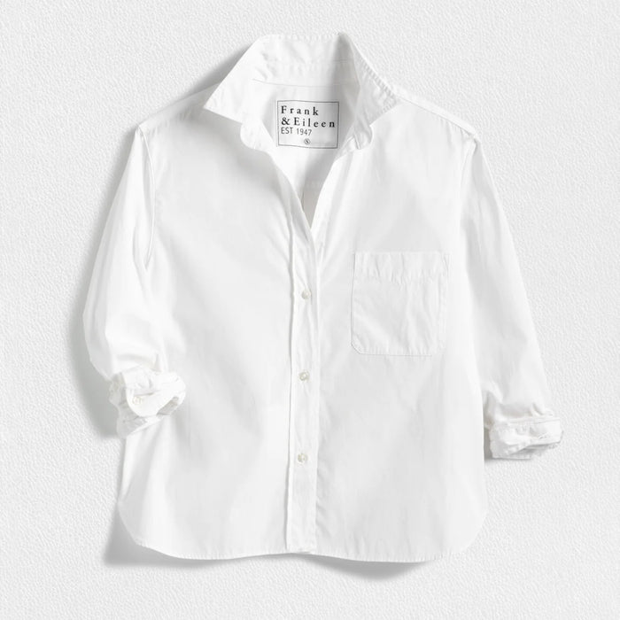 The FRANK & EILEEN Silvio Untuckable Button-Up Shirt in Superluxe Cotton, featuring a chest pocket and rolled-up sleeves, is laid flat on a textured surface. The inside label reads "Frank & Eileen EST 1947.