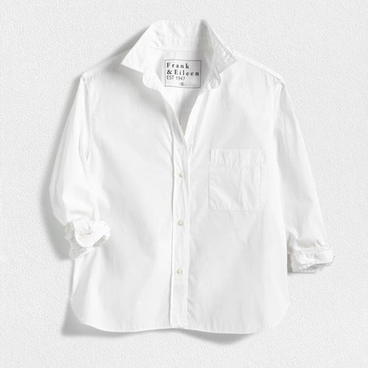 The FRANK & EILEEN Silvio Untuckable Button-Up Shirt in Superluxe Cotton, featuring a chest pocket and rolled-up sleeves, is laid flat on a textured surface. The inside label reads "Frank & Eileen EST 1947.