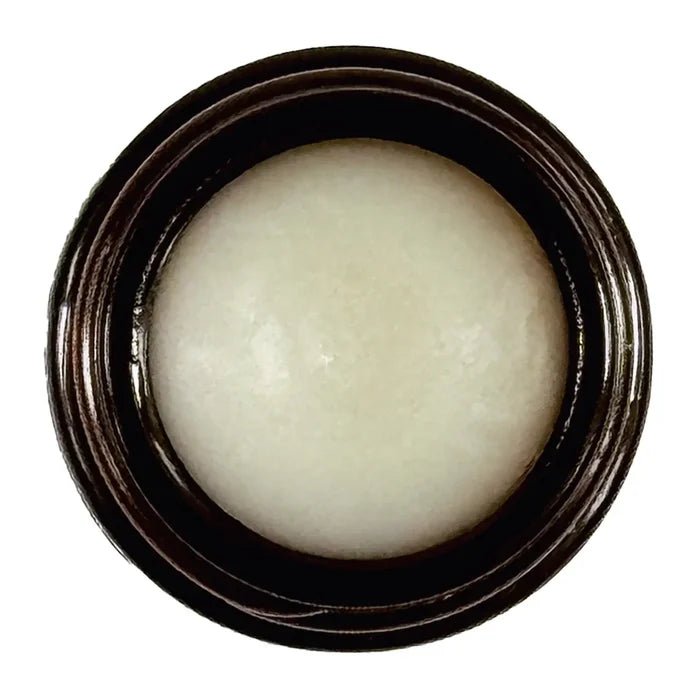 White cream in a black container on a white background