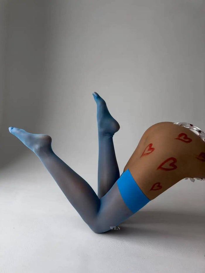 GLAM Stockings Blue displayed on legs, showcasing a smooth finish and stylish blue detail with heart designs.