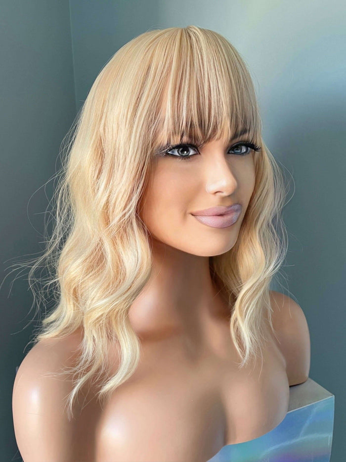 Mannequin head with a blonde wig on a gray background