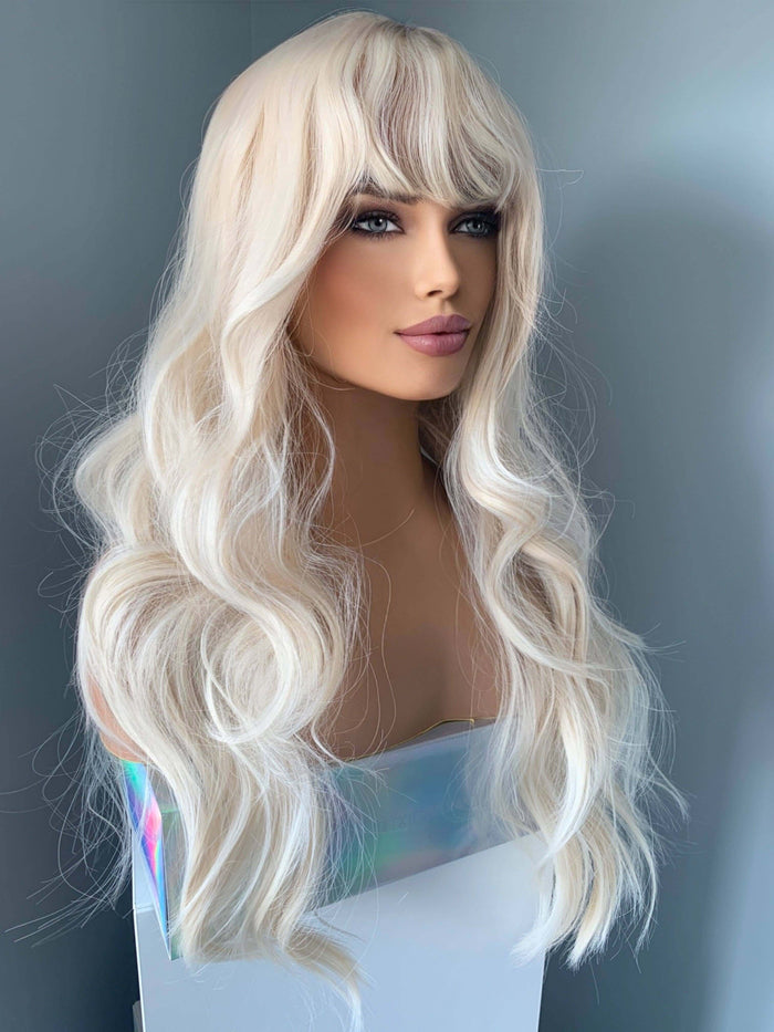 Gwen Long Blonde Layered Wig with Bangs displayed on a mannequin, featuring soft waves and curtain bangs, perfect for a glam look.