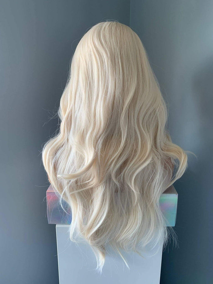 Back view of the Gwen Long Blonde Layered Wig showcasing soft waves and curtain bangs.