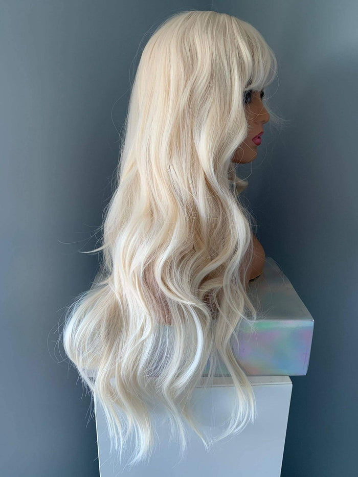 Gwen Long Blonde Layered Wig with Bangs displaying soft tousled waves and curtain bangs.