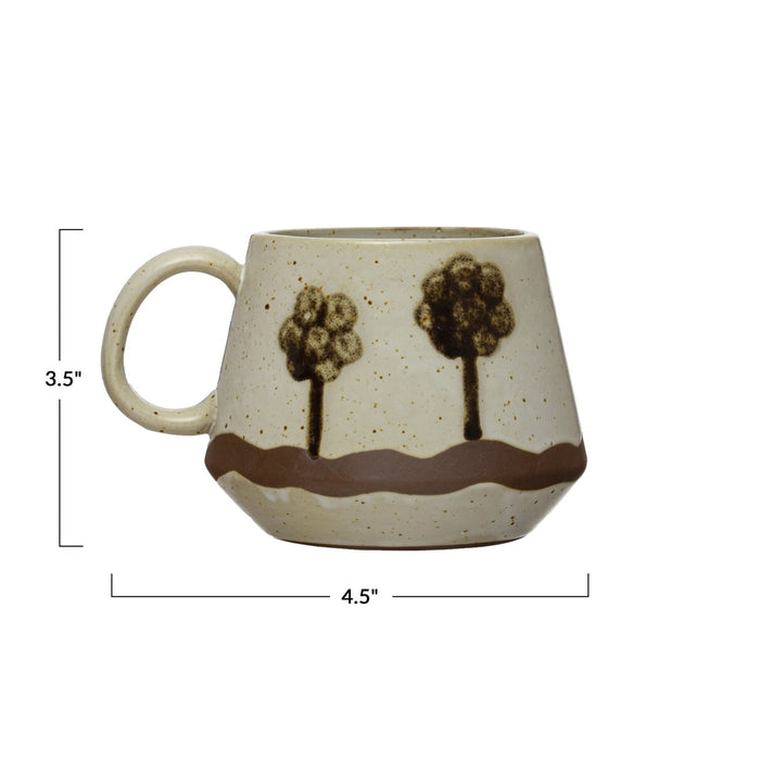 The HAND-PAINTED STONEWARE MUG WITH TREES by CREATIVE COOP is a beige stoneware mug with a large handle, wavy brown stripe, and two stylized tree designs, perfect for adding rustic charm to your coffee routine.